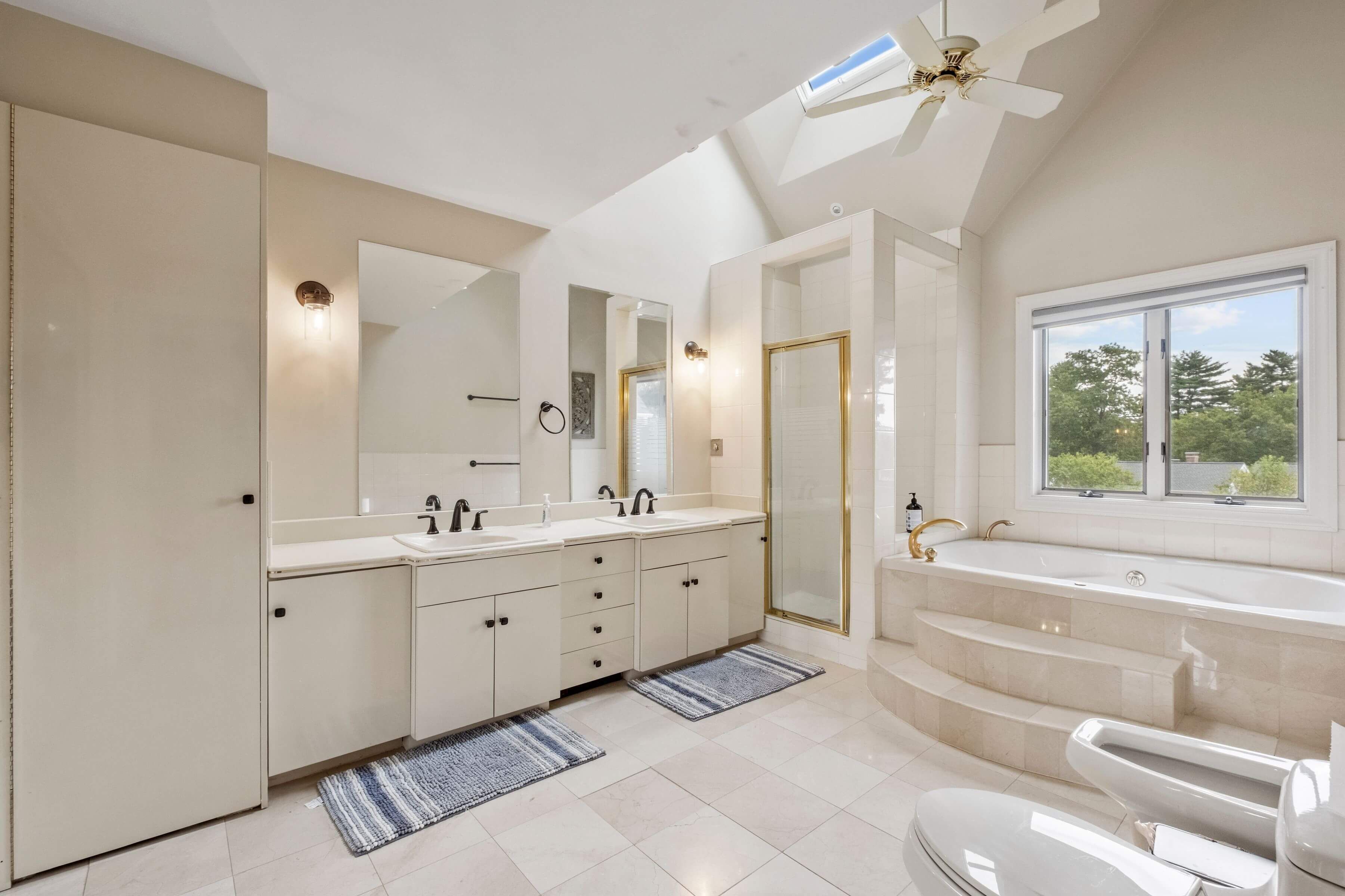 Une salle de bain moderne dotée d’une grande baignoire, de deux vasques et d’une douche à l’italienne.