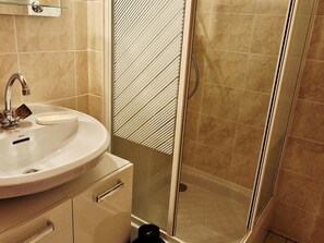 Ein Badezimmer mit Waschbecken, Spiegel und Dusche.