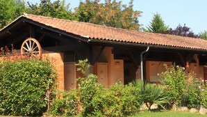 A rustic building with a tiled roof and a large wooden wheel structure. - Mobile Home 34m² with Terrace for 6 in Dévillac (Dévillac)