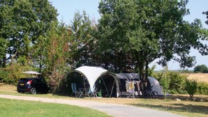 A campsite with two tents, a car, and a bicycle. - Mobile Home 34m² with Terrace for 6 in Dévillac (Dévillac)