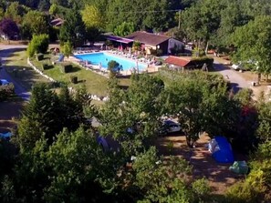 A residential area with a swimming pool, a house, and surrounding greenery. - Mobile Home 34m² with Terrace for 6 in Dévillac (Dévillac)