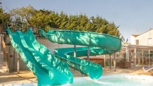 Ein Schwimmbecken mit einer grünen Wasserrutsche.