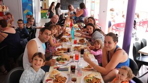 A group of people dining at a restaurant with a long table filled with food and drinks. - Mobile home with terrace for 7 people (Bretignolles-sur-Mer)