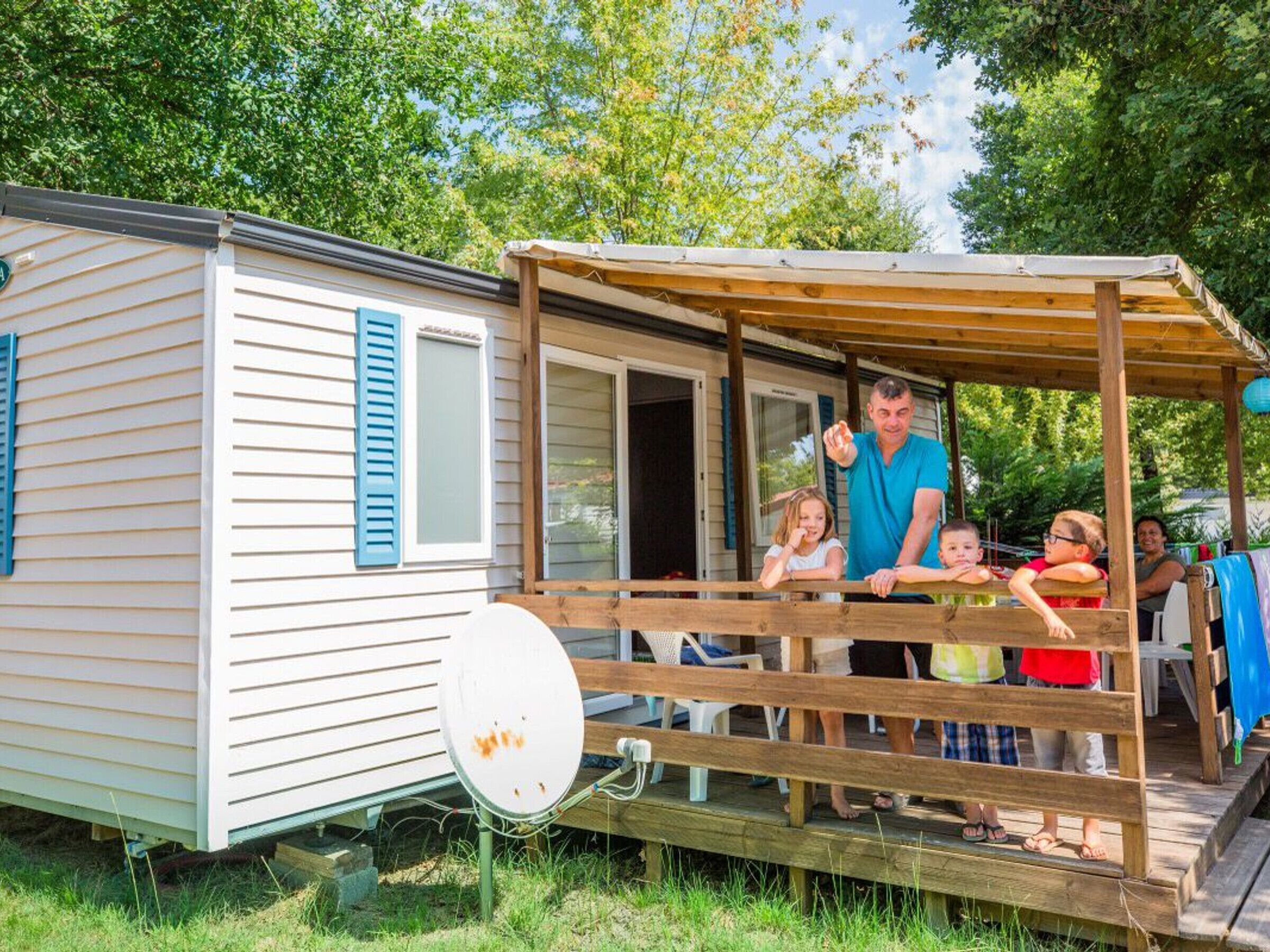 Ein Wohnmobil mit einer Holzterrasse und einer Sat-Schüssel.