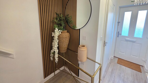 A hallway with a wooden slat wall, a round mirror, a wicker basket, and a vase with white flowers. - Spacious| Modern House |Close to Sites, beach,|Contractors,  families welcome (Yeovil)