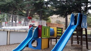A playground with two blue slides and a wooden climbing structure. - Cozy mobile home with terrace in Sournia (Sournia)
