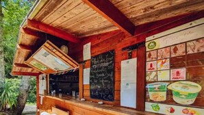 A rustic wooden cabin with a chalkboard menu, outdoor seating, and a refrigerator. - Chalet for 6 with Terrace (Fenouillet)