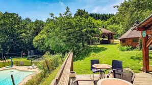 A wooden deck with outdoor seating, a pool, and a gazebo in a lush, green environment. - Chalet for 6 with Terrace (Fenouillet)