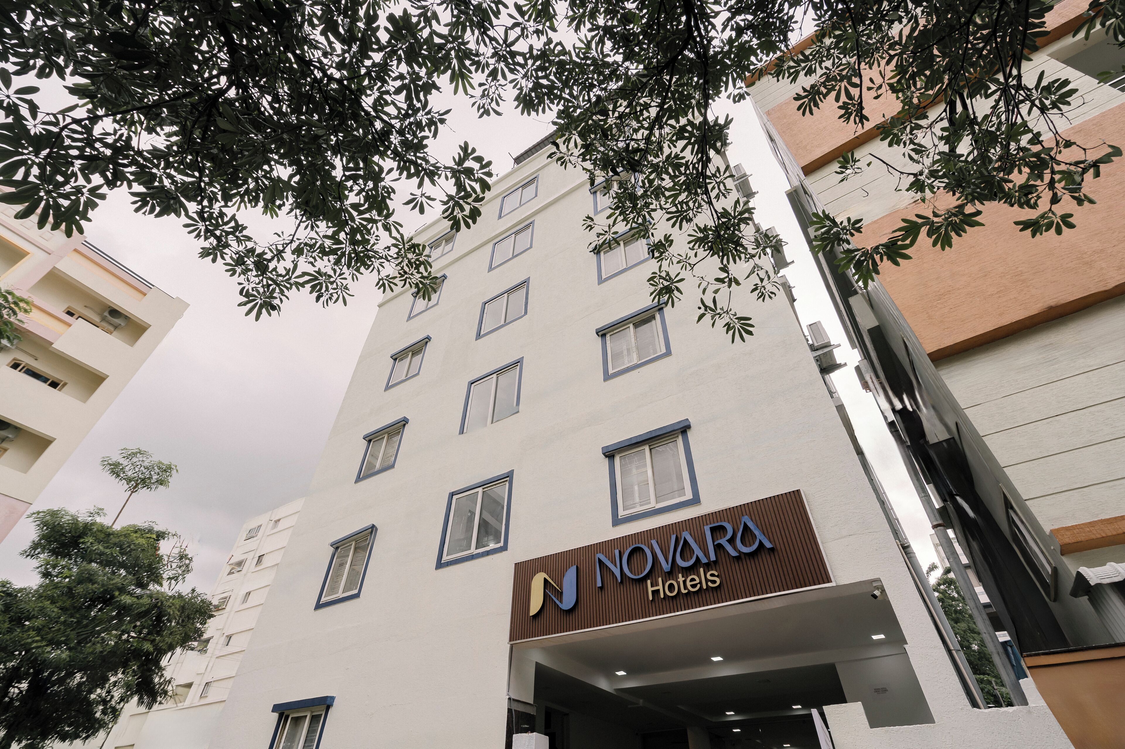 Un edificio de hotel de varios pisos con un letrero que dice Novara Hotels.