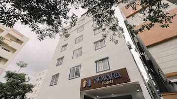 Un edificio de hotel de varios pisos con un letrero que dice Novara Hotels.