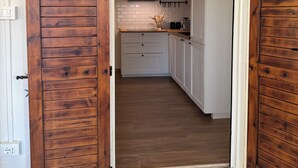 A kitchen with wooden cabinets, a white countertop, and a black range hood.