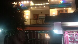 A two-story building with a balcony and a shop at the ground level. - Marari beach daze homestay (Alappuzha)