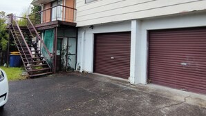 Een gebouw met twee verdiepingen, een garage en een overdekt terras.