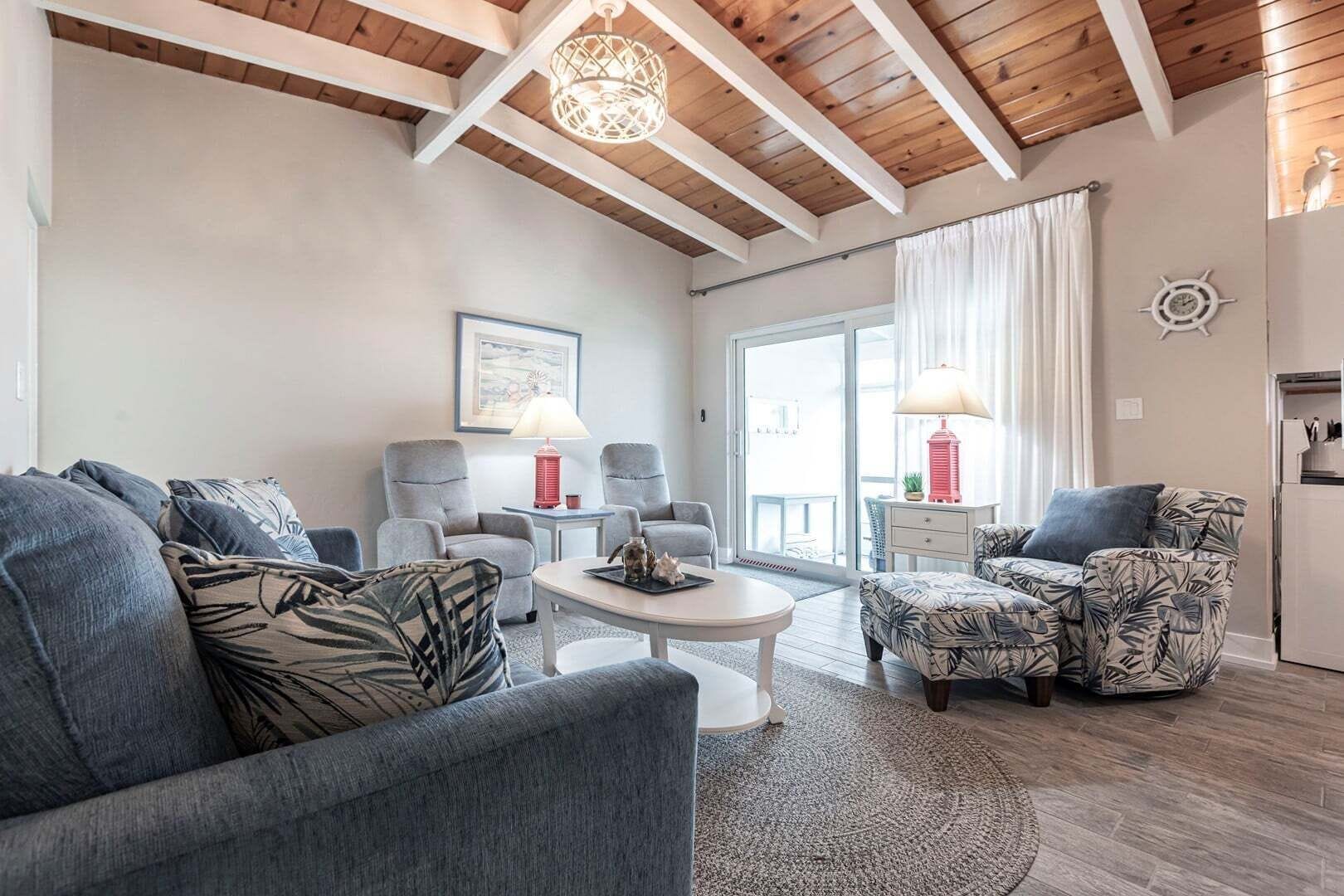 Un salón moderno con techo alto, una mesa de centro redonda y vistas al exterior.