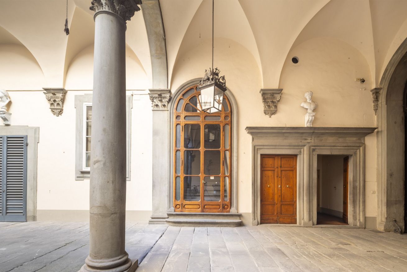 Un intérieur spacieux avec une grande porte en bois, une colonne et une lanterne suspendue.