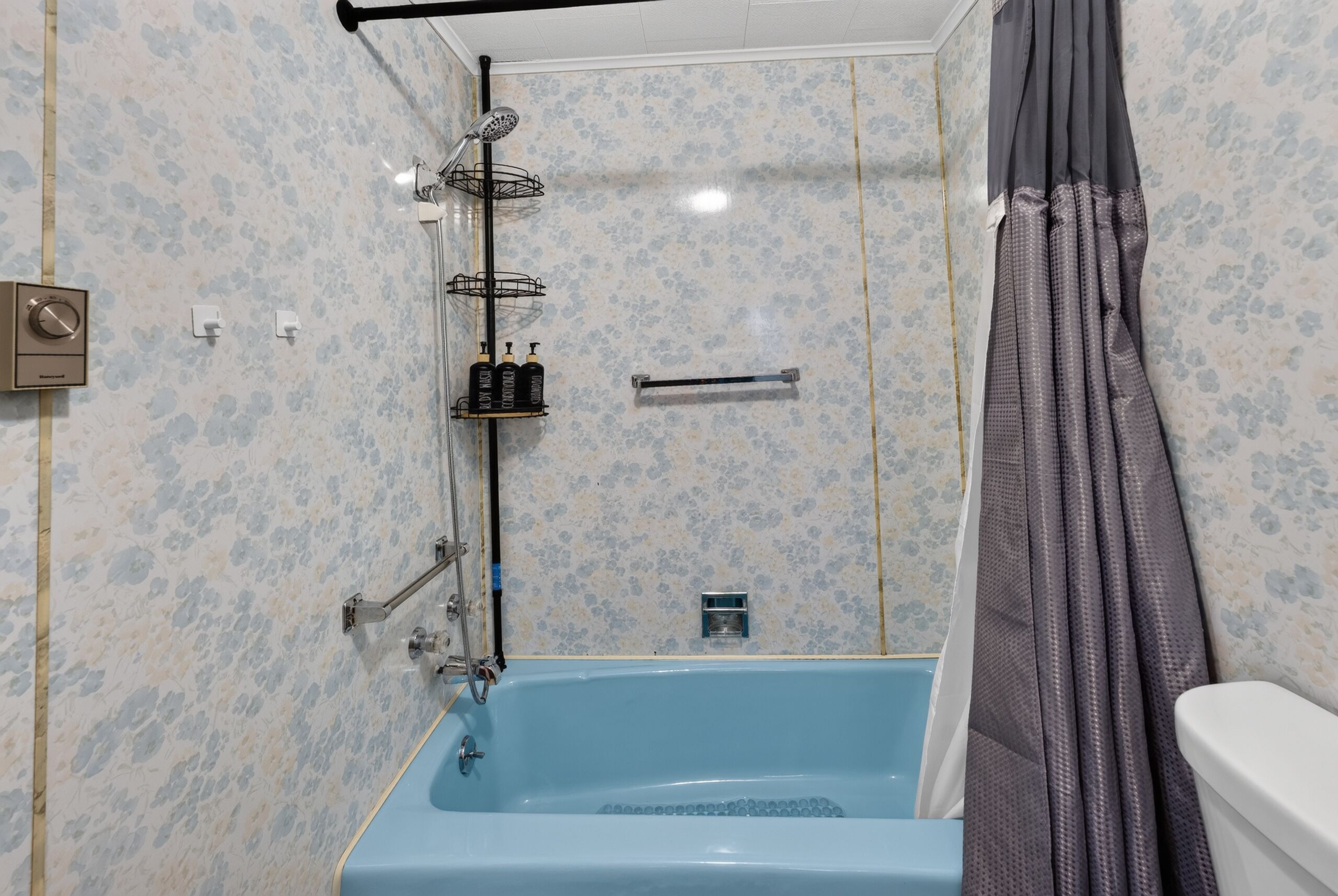 A bathroom with a bathtub, shower, and toilet.