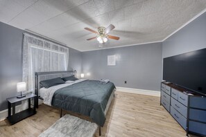 A bedroom with a bed, nightstand, lamp, dresser, and ceiling fan. - Charming 1-bedroom apartment in welcoming Carbondale with AC (Carbondale)