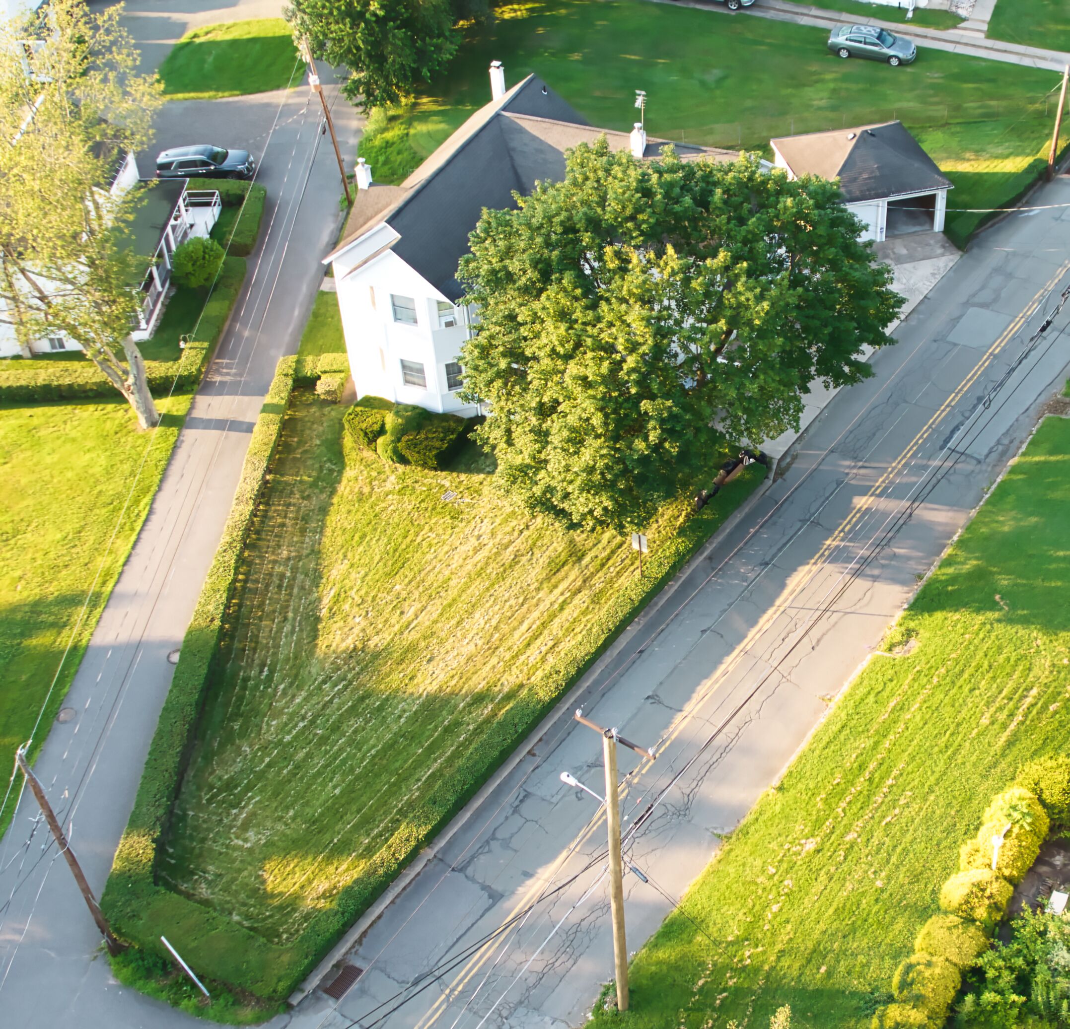 Vue aérienne d’un quartier résidentiel avec une maison, une allée et une rue.