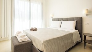 Une chambre d’hôtel avec un grand lit, une table de chevet et une fenêtre avec des rideaux.