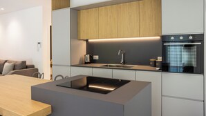 Une cuisine moderne dotée d’une cuisinière intégrée, d’un évier et d’armoires en bois.