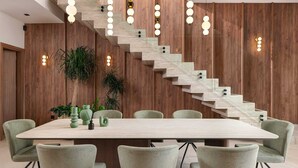 A modern interior with a staircase, dining table, chairs, and potted plants. - Lanik Luxury Pool Villa (Αφάντου)