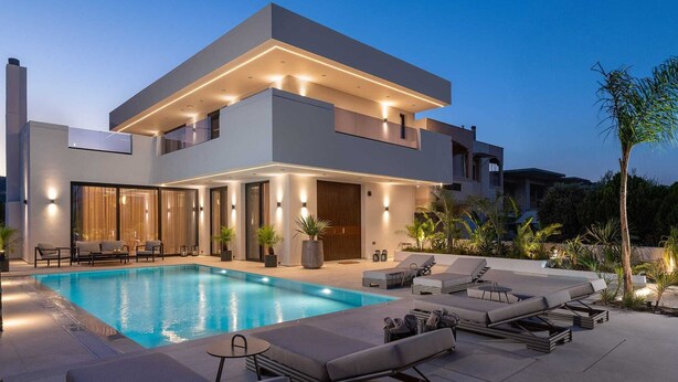 A modern two-story house with a swimming pool, outdoor seating, and a well-lit entrance. - Lanik Luxury Pool Villa (Αφάντου)