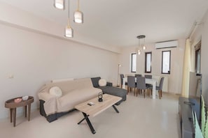 Una sala de estar moderna con sofá, mesa de centro y comedor.