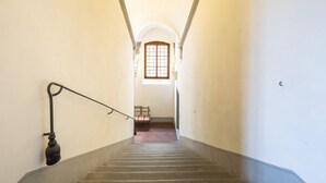 A staircase leading to a room with a window and a bed. - Tower View Apartment (Firenze)