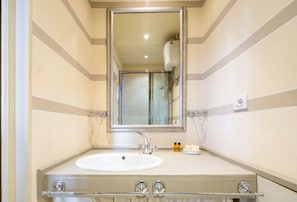 A bathroom with a white sink, a large mirror, and a glass shower enclosure.
