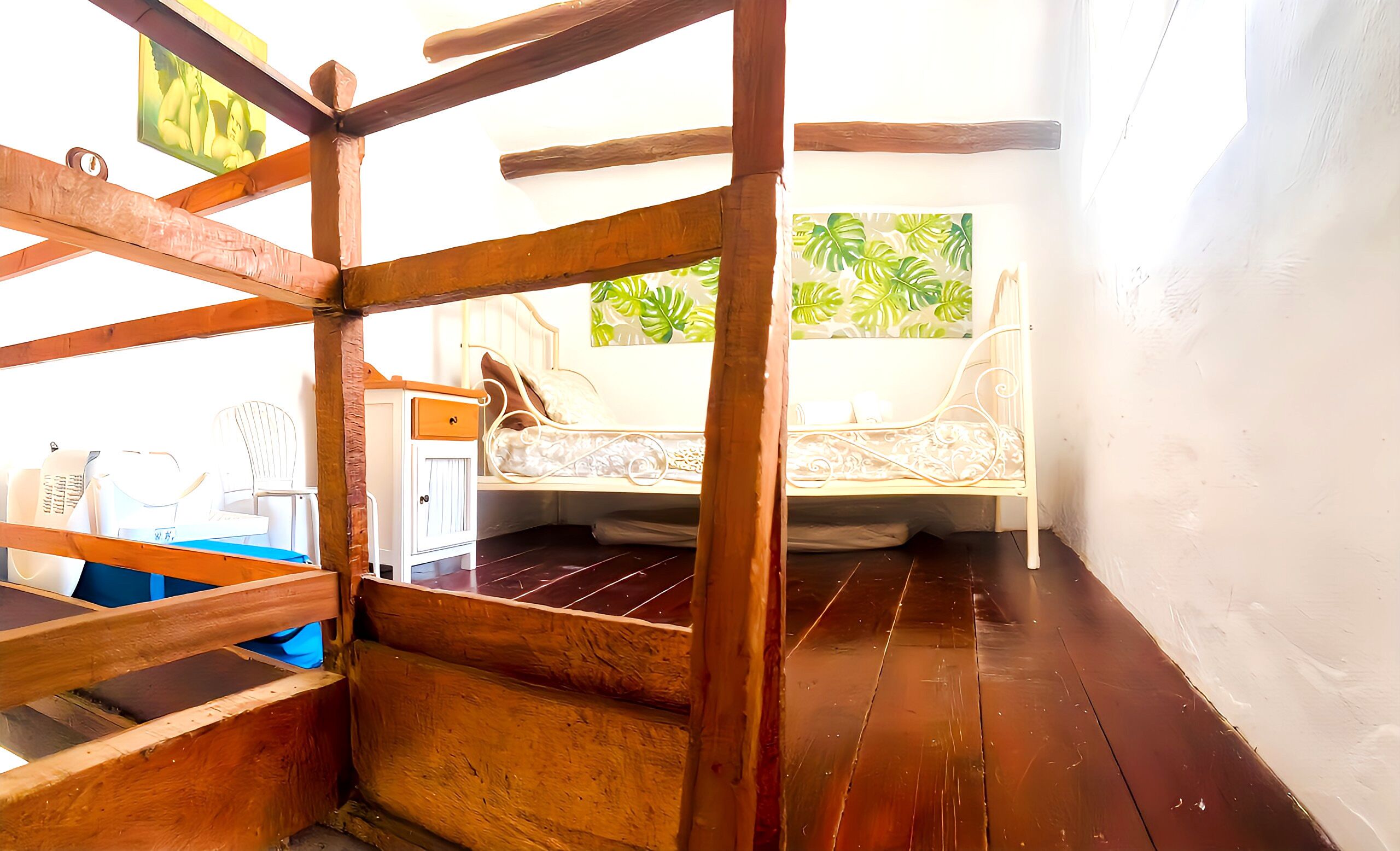 Una habitación con cama, un escritorio pequeño y ventana con vista tropical.