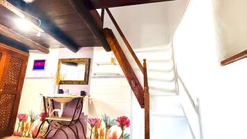 Un baño con techo de madera, lavamanos, espejo y un mural floral en la pared.