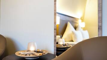 Un coin salon confortable avec une assiette de collations et une bougie sur une petite table.