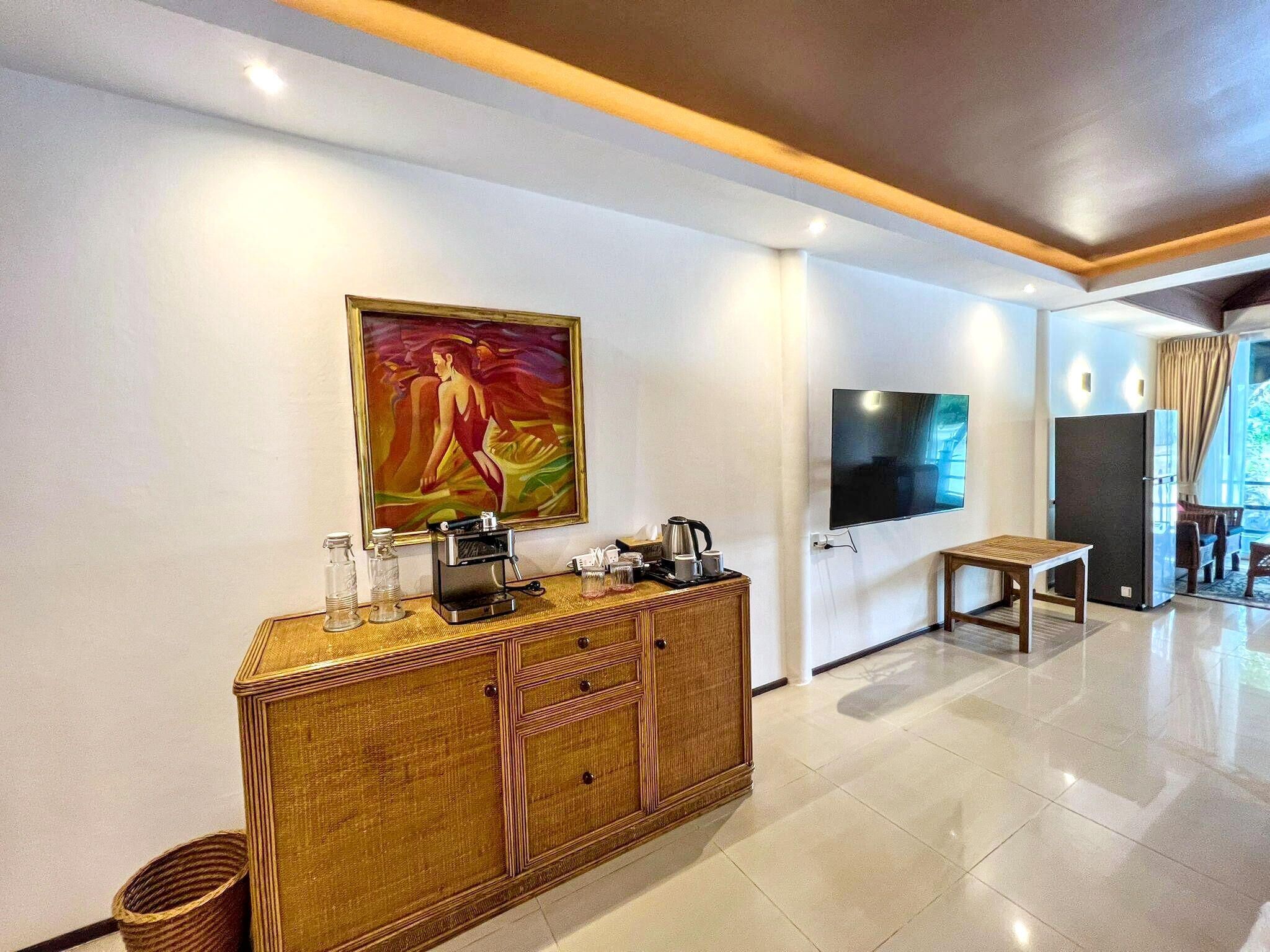 Une chambre d’hôtel moderne dotée d’un grand tableau, d’une télévision, d’un minibar et d’un coin repas avec vue.