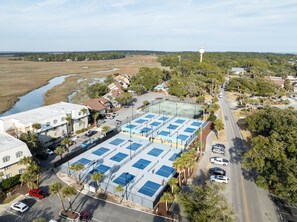An aerial view of a residential area with a large parking lot, multiple buildings, and a river in the background.
