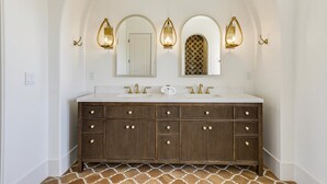 A bathroom with a double vanity, two sinks, and a large mirror.