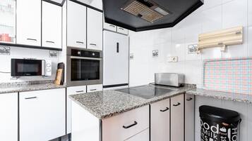 Een magnetron, een oven, een kookplaat, een vaatwasser