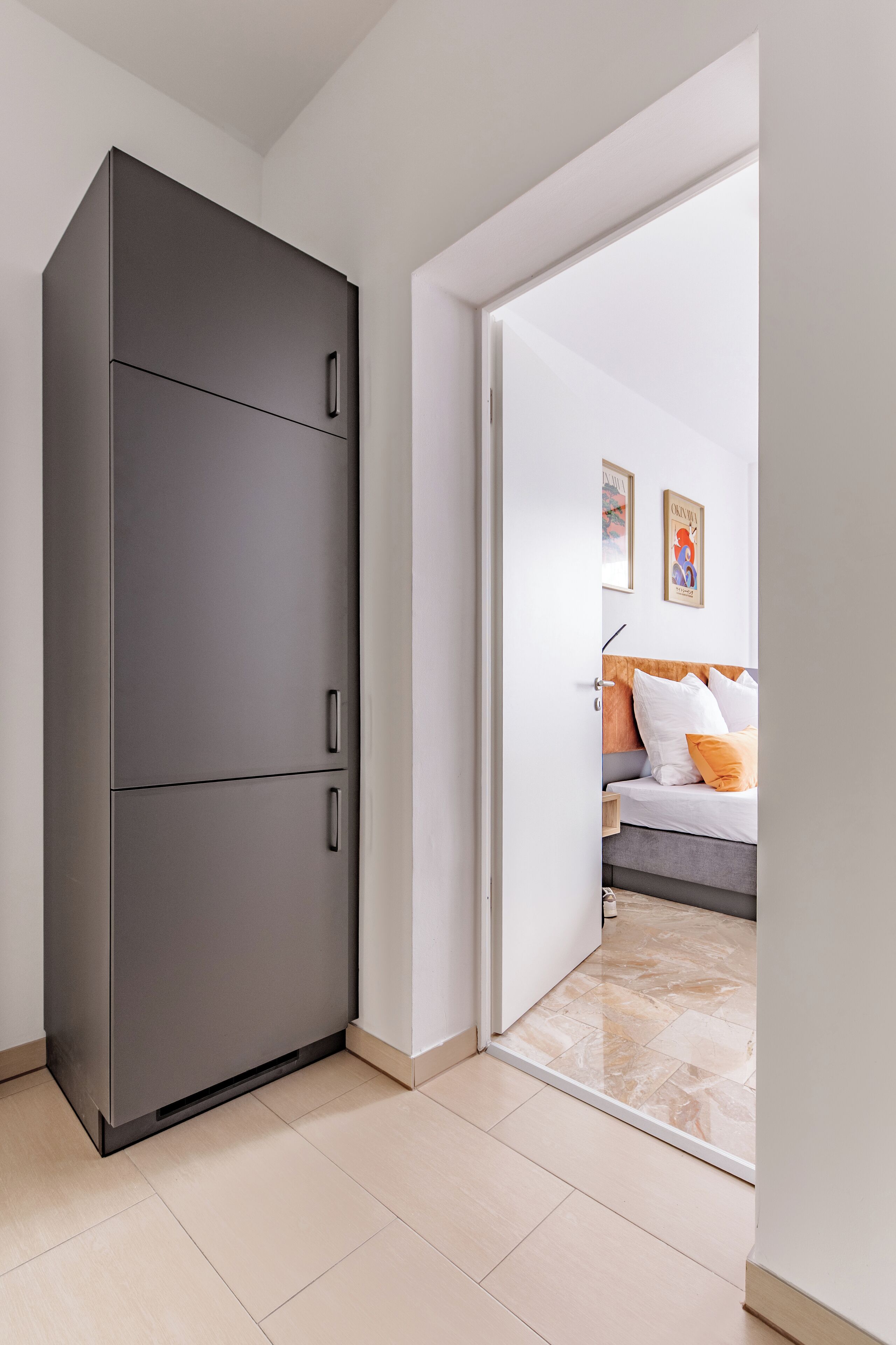 Ein modernes Schlafzimmer mit einem Bett, einem Kleiderschrank und einer Tür zu einem anderen Raum.