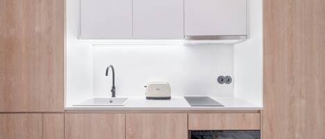 A modern kitchen with a built-in sink, a toaster, and an oven.