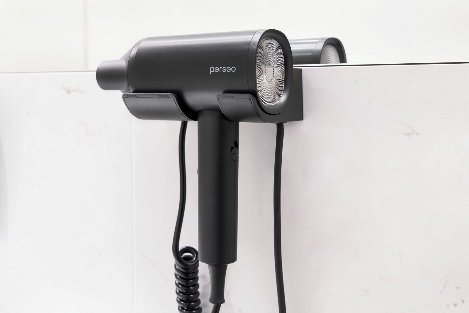 A hair dryer mounted on a wall with a cord.