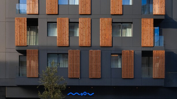 A modern building with multiple balconies, each with vertical wooden slats. - Moov Apartments Boavista (Porto)