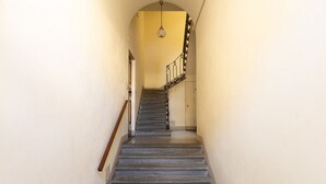 Eine enge Treppe mit einer Holzhandläufe und einer schwarz-weißen Geländer, die zu einer Tür oben führt.