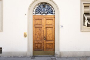 A double wooden door with a brass handle, a brass plate, and a number '10' sign on the wall. - Tucked away in the heart of San Frediano, Florence’s most authentic neighborhood, this romantic apartment blends history with modern comfort. Recently renovated with curated details and a stunning frescoed ceiling, it is the perfect retreat for couples (Firenze)