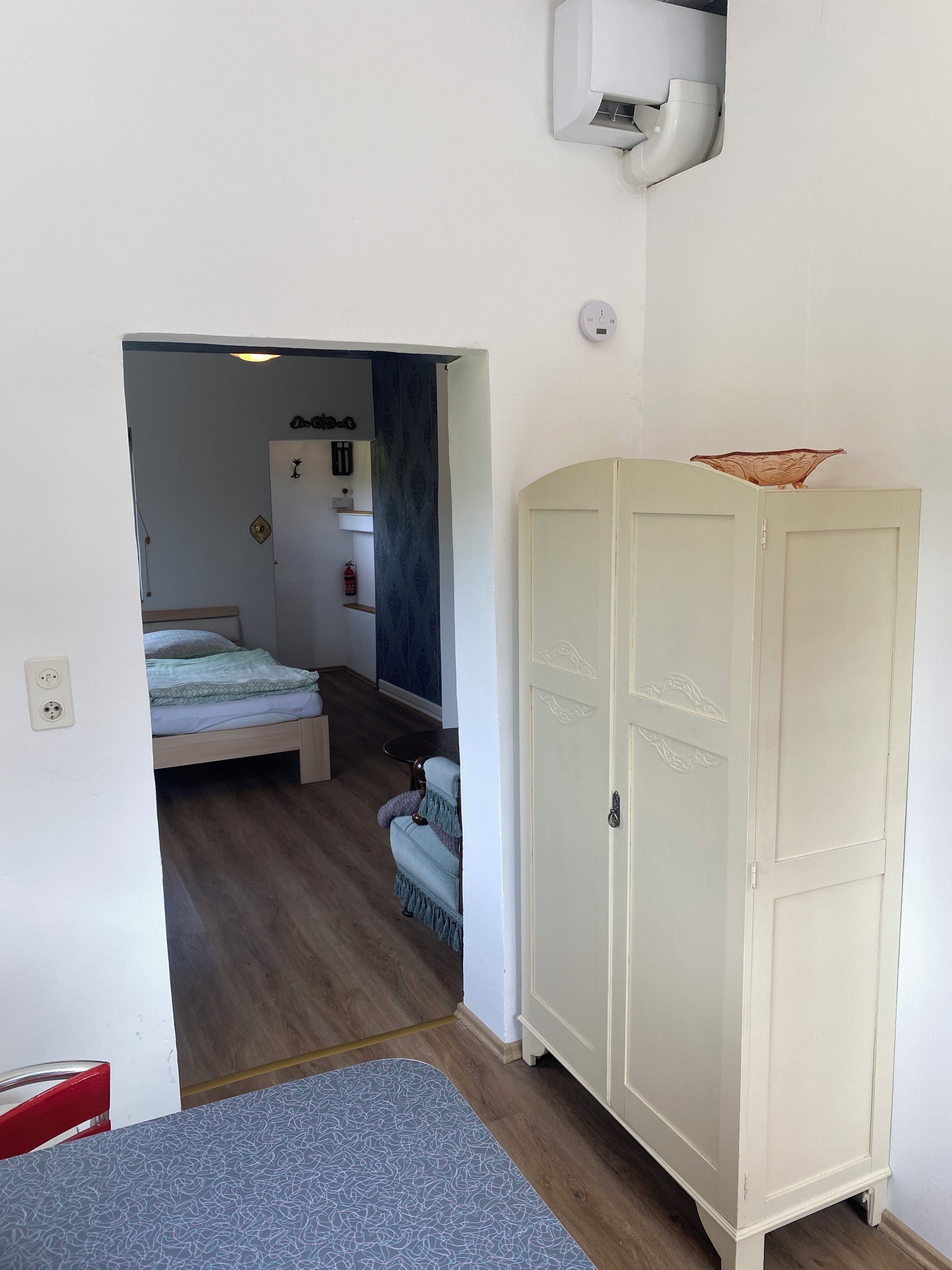 Ein Zimmer mit einem Bett, einem Schrank, einem kleinen Tisch und einem Stuhl.