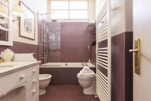 A compact bathroom with a shower, toilet, and sink.