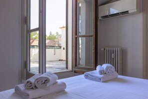 A hotel room with a bed, a window, and a radiator. - Pitti Secret Rooftop (Firenze)