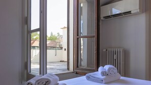 A hotel room with a bed, a window, and a radiator. - Pitti Secret Rooftop (Firenze)