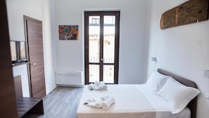 Une chambre à coucher avec un lit, un banc, un radiateur, une porte et une fenêtre.