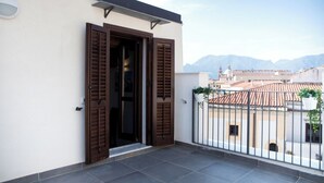 Un balcon offrant une vue sur la ville et les montagnes.