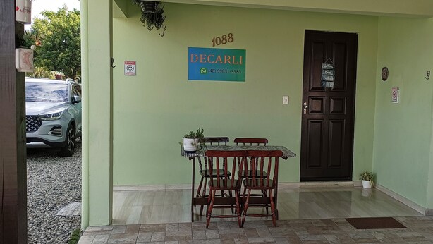 A building entrance with a sign reading "DECARLI" and a contact number. - POUSADA DECARLI (Florianopolis)