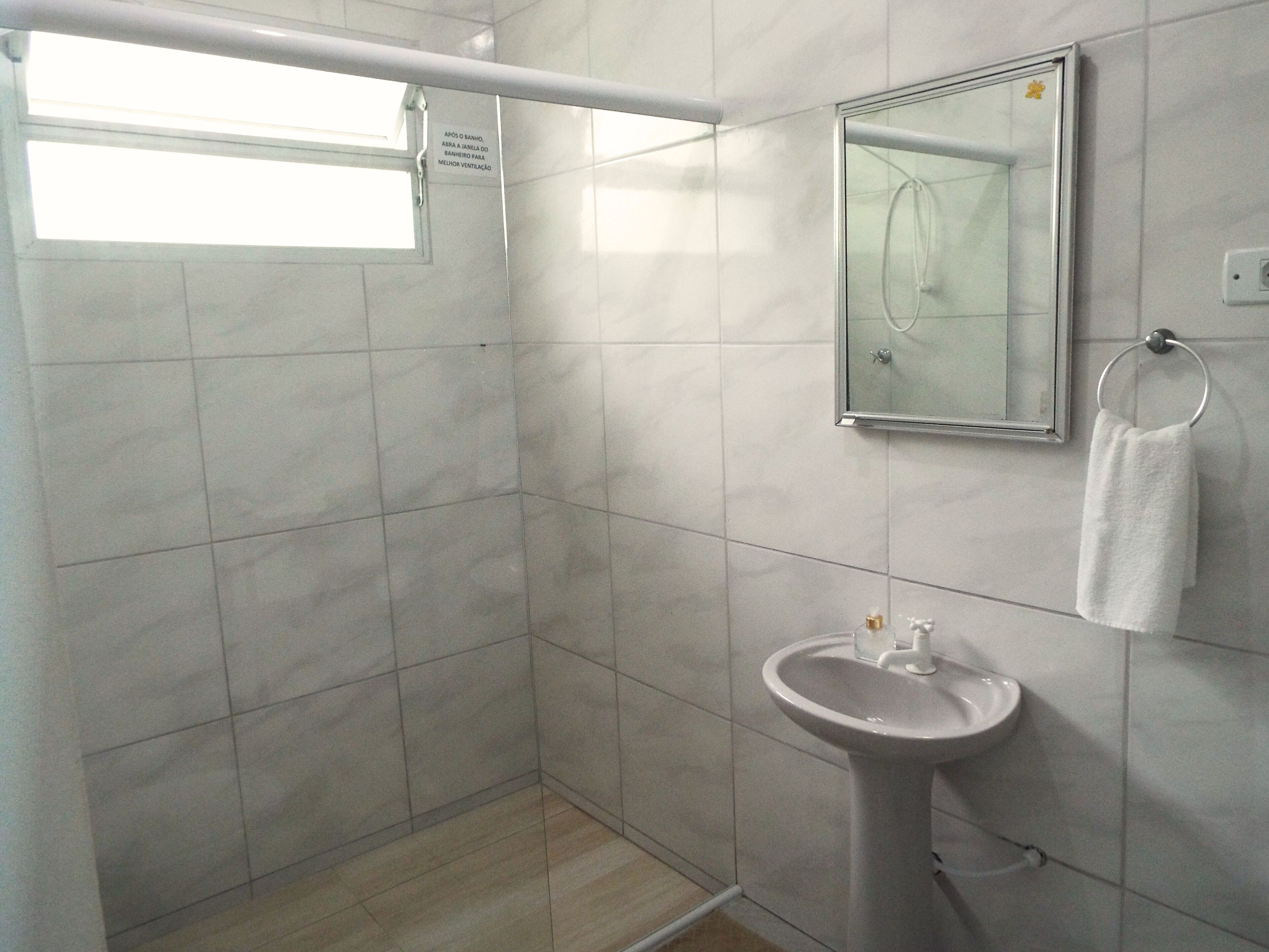 A bathroom with a shower, a sink, and a mirror.